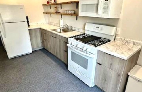 Arnolds Park Apartment | Cozy 2-bedroom suite with full kitchen, living room (couch, 2 chairs), dining table (2 stools), smart TV with cable. Perfect for short or long stays.