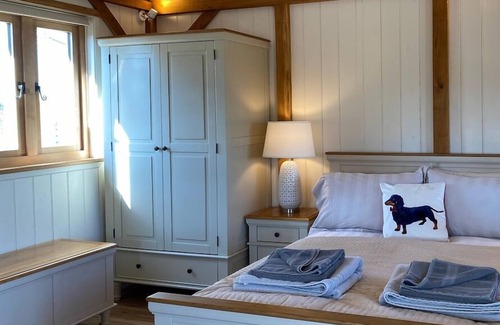 Ham Cabin | Gatehouse Lodge a bespoke Lodge on working farm with a distant sea view and a secluded garden with fire.