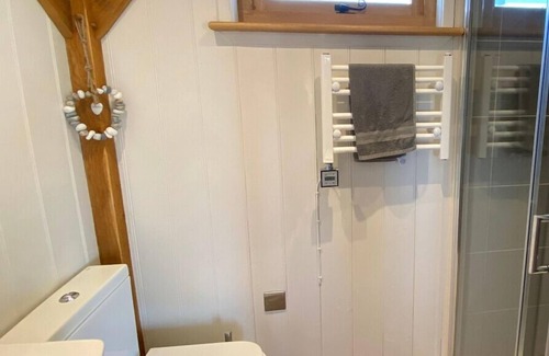 Ham Cabin | Gatehouse Lodge a bespoke Lodge on working farm with a distant sea view and a secluded garden with fire.