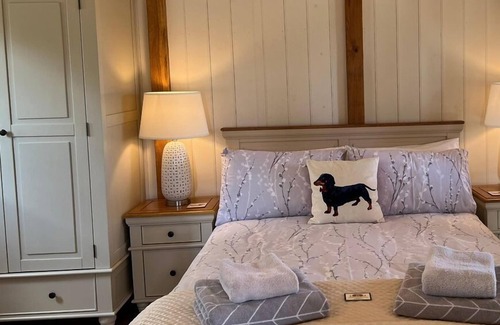 Ham Cabin | Gatehouse Lodge a bespoke Lodge on working farm with a distant sea view and a secluded garden with fire.