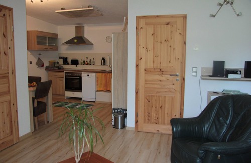 Friedrichroda House | Modernly furnished bungalow with fireplace, surrounded by greenery.
