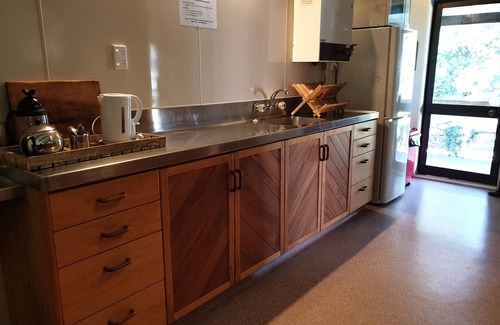 Western Lake Cabin | Rustic cabin & large kitchen block nestled in a native garden.