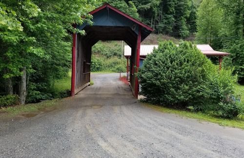 Upper Peachtree Cabin | Rustic two-story cabin on creek with covered bridge and water wheel.