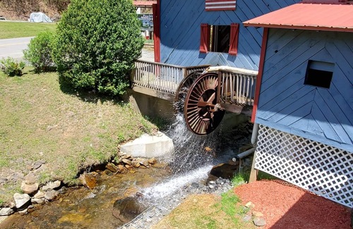 Upper Peachtree Cabin | Rustic two-story cabin on creek with covered bridge and water wheel.