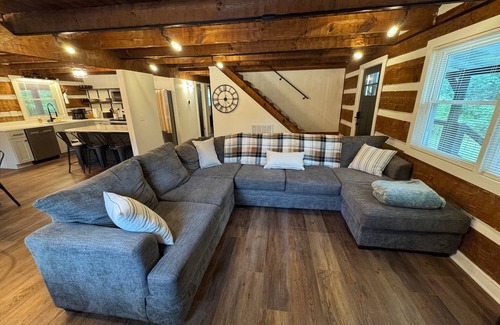 Manchester Cabin | Stunning hand-hewn log cabin blending rustic charm with modern comfort. Minutes from Manchester's dining & shops, yet secluded enough to truly relax. Warm timber beams, cozy furnishings, smart TV & spacious living. 4 bedroom, sleeps 12.