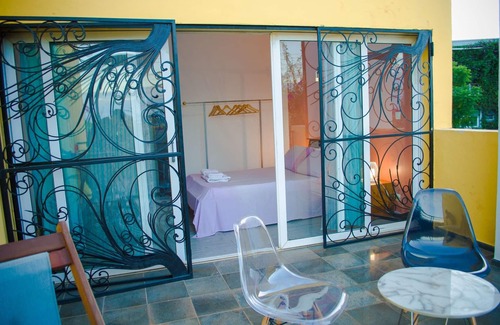 Ambohibao Villa | The white-orange bedroom with a pleasant view overlooking the lake