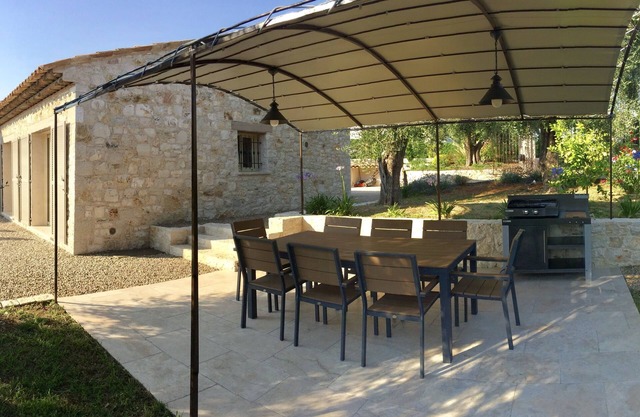 A stone farmhouse in the countryside surrounded by olive trees