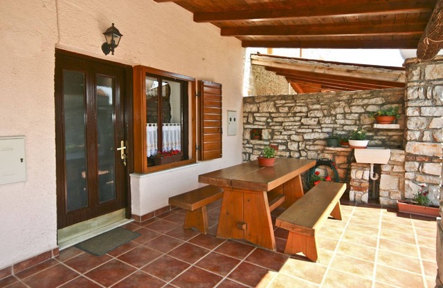 Rustic stone house with sunshade on a fenced property