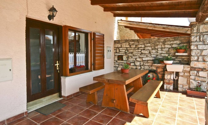 Orihi House | Rustic stone house with sunshade on a fenced property